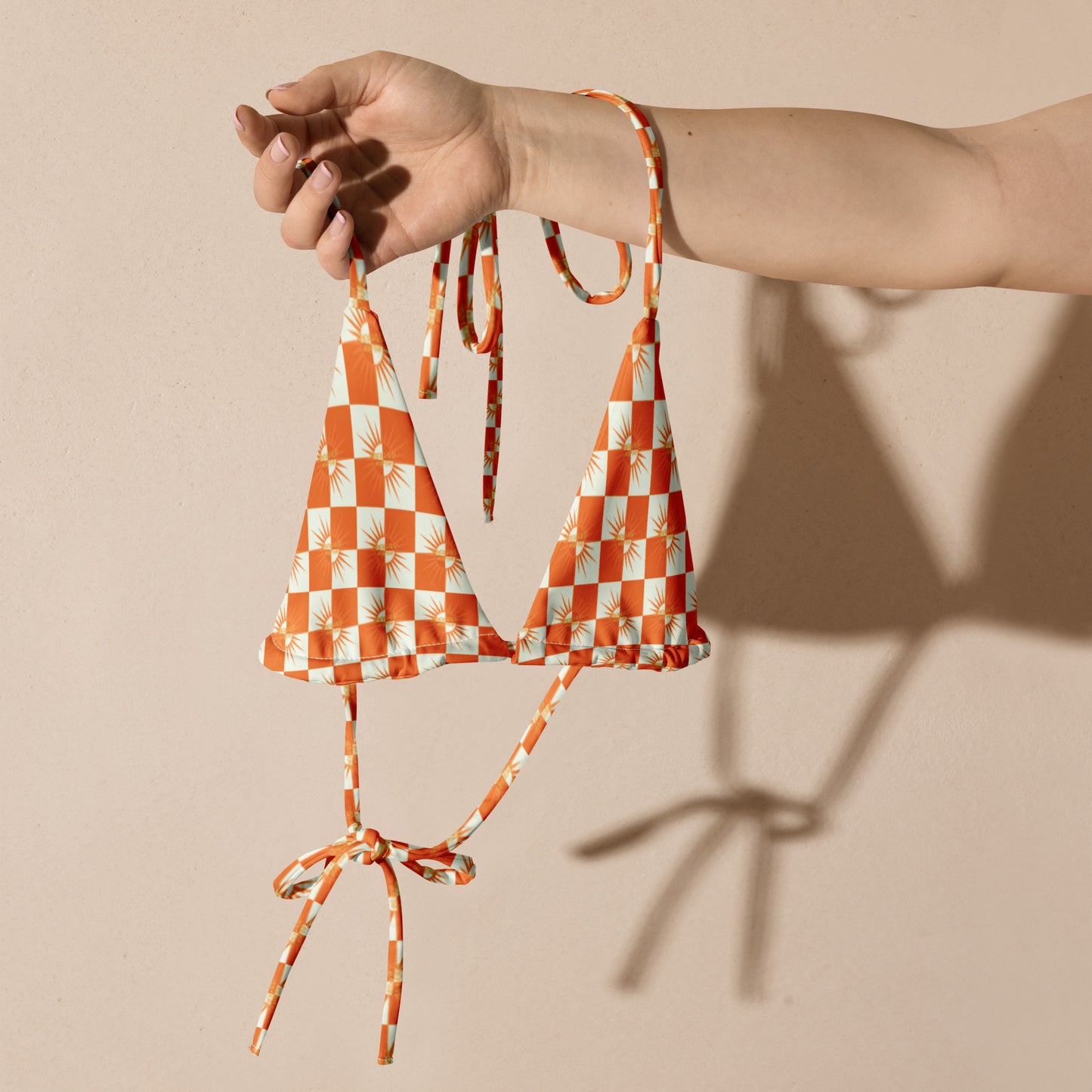 Turn heads with vibrant summer style.
The White &amp; Orange Checked Bikini String Top from FreelivdMafiia blends playful pattern with functional design. Adjustable string ties at the neck and back give you a customizable fit, while the fresh checked print pops against sun-kissed skin. Perfect for beach days, pool parties, or reckless water escapades.