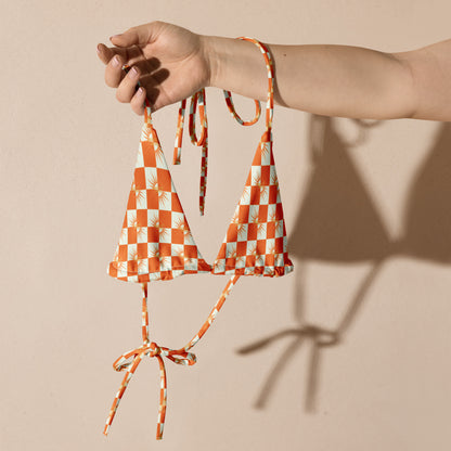 Turn heads with vibrant summer style.
The White &amp; Orange Checked Bikini String Top from FreelivdMafiia blends playful pattern with functional design. Adjustable string ties at the neck and back give you a customizable fit, while the fresh checked print pops against sun-kissed skin. Perfect for beach days, pool parties, or reckless water escapades.